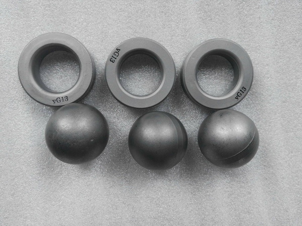 Tungsten carbide valve balls and valve seats for high-pressure flow control systems